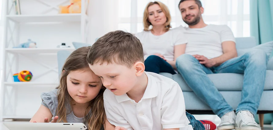 A father and teenage daughter looking at a phone screen together, smiling and talking, representing open communication.